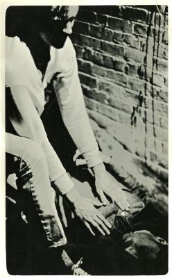 Photograph of two figures against a brick wall